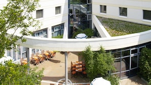 A modern building with multiple floors, large windows, and a curved glass structure.