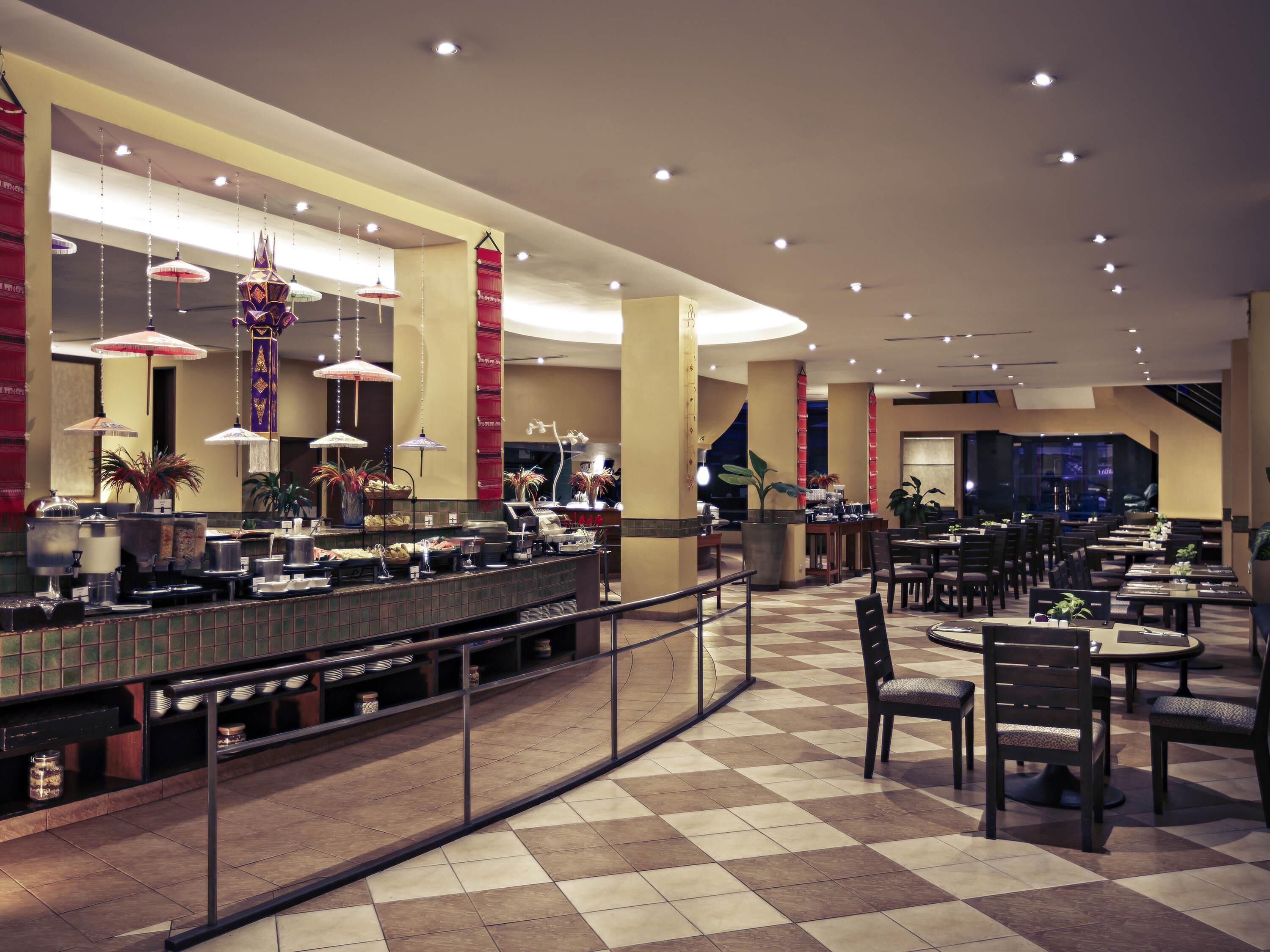 A hotel lobby with a check-in counter, seating area, and a large window.