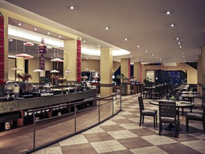 Un hall d’hôtel comprenant un comptoir d’enregistrement, un espace salon et une grande fenêtre.