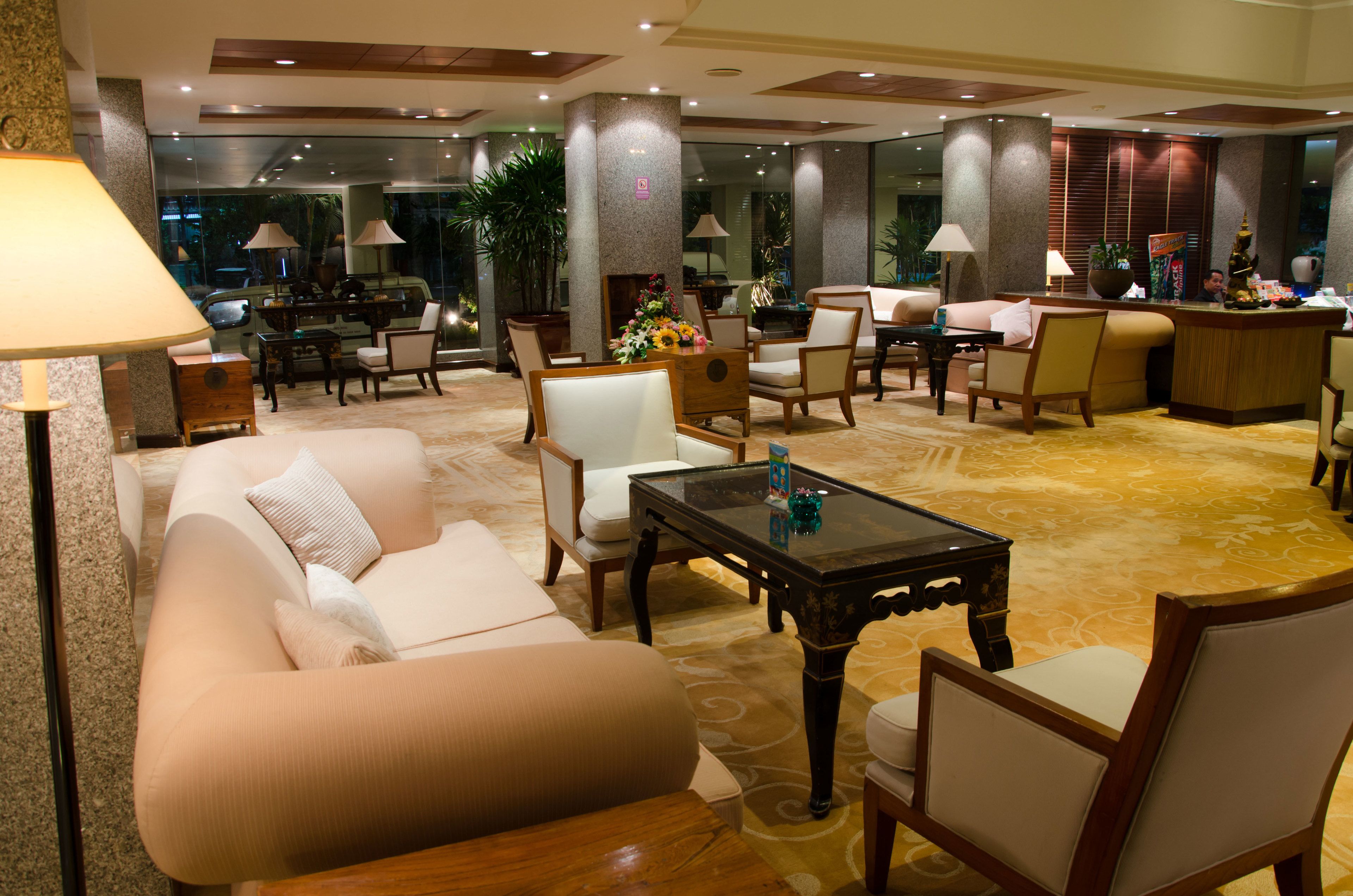 Un'ampia hall con divano, poltrone, tavolino e reception.