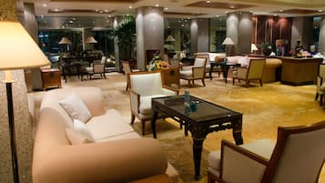 Un'ampia hall con divano, poltrone, tavolino e reception.