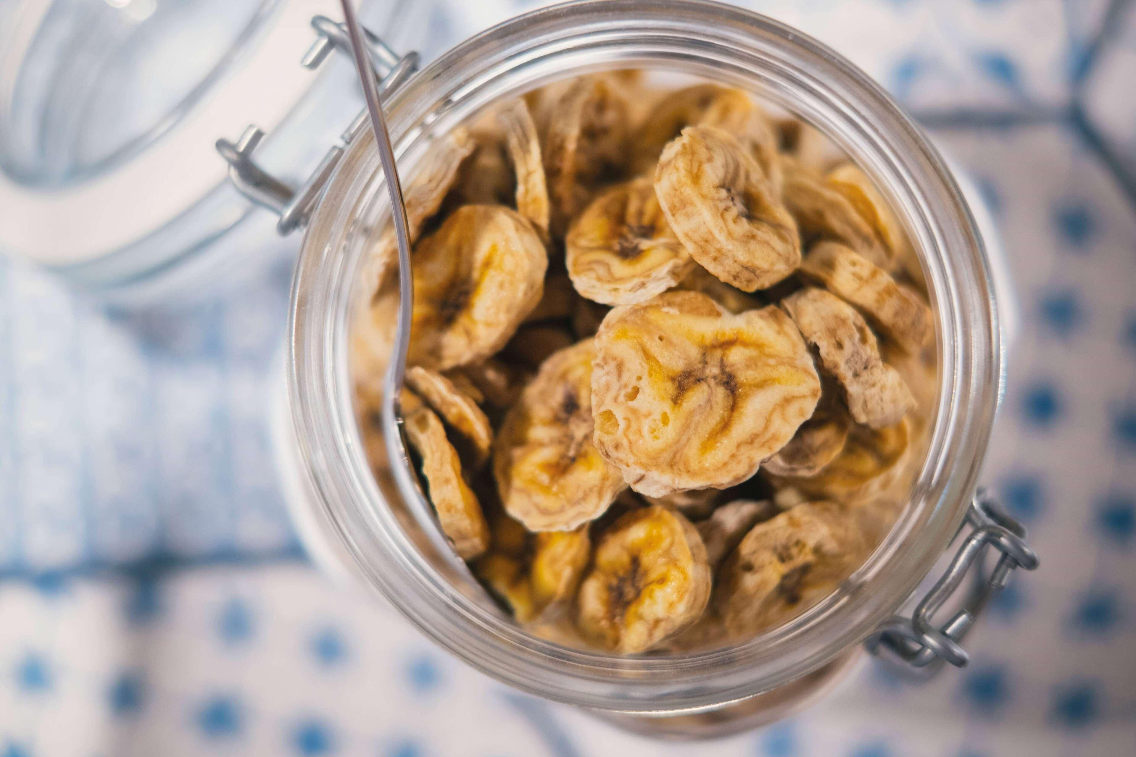A glass jar filled with dried banana slices.