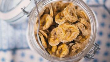 A glass jar filled with dried banana slices.