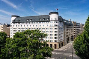 Un hôtel à plusieurs étages doté d’une architecture remarquable, caractérisé par une façade incurvée et un drapeau bien visible au sommet.