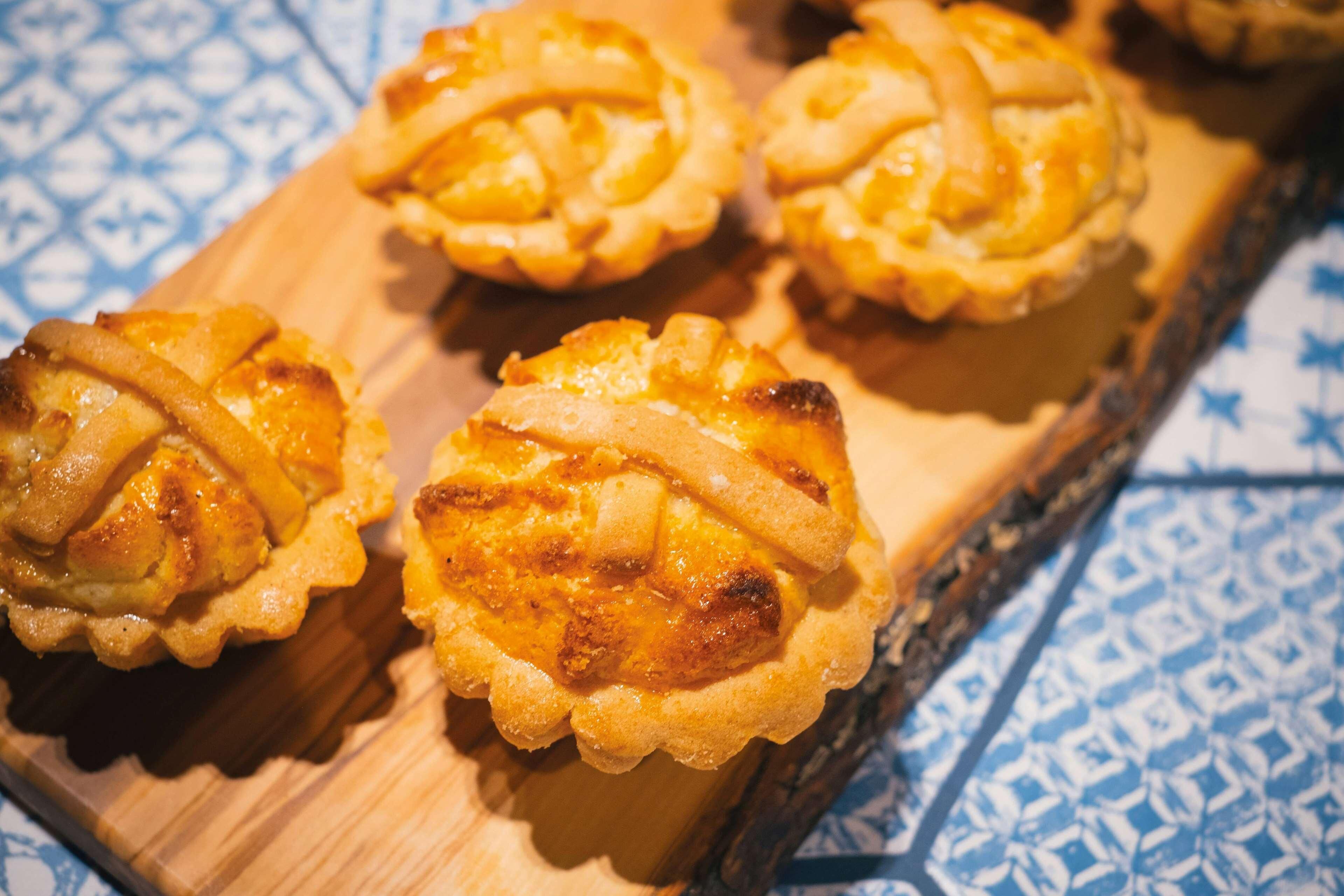 A wooden board with four pastries on it.