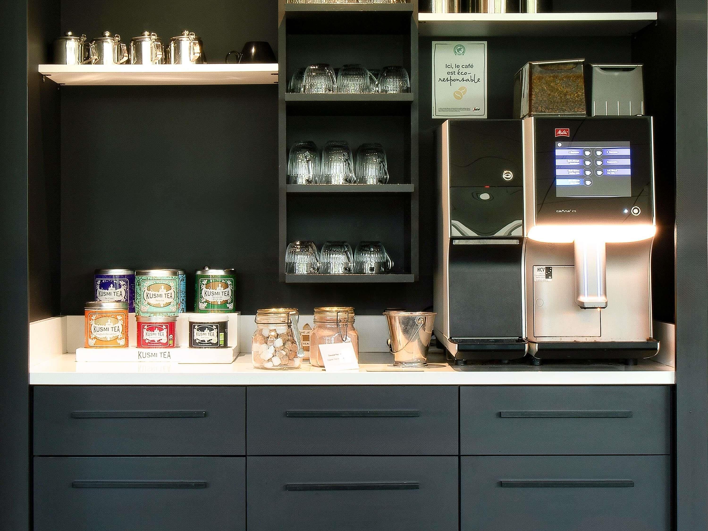 Eine Kaffeestation mit Kaffeemaschine, Gläsern und Teebehältern.