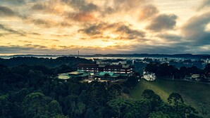 A hotel with a large building and a swimming pool, surrounded by dense forest and hills in the background. - Serra Alta Hotel (Sao Bento do Sul)