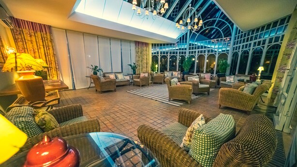 A spacious indoor area with wicker furniture, a glass table, and a ceiling with a skylight. - Serra Alta Hotel (Sao Bento do Sul)