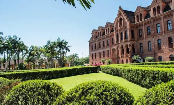Un edificio grande e histórico con múltiples ventanales de arco y una fachada simétrica.