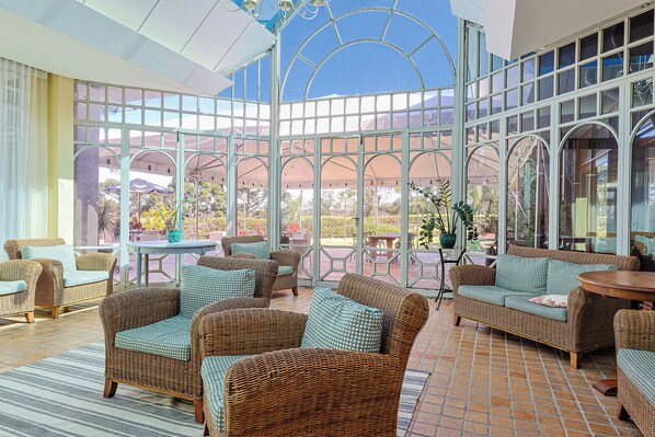 A conservatory with wicker furniture and a glass ceiling. - Serra Alta Hotel (Sao Bento do Sul)