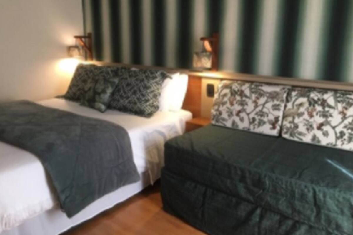 A room with two beds, each with a different patterned headboard.