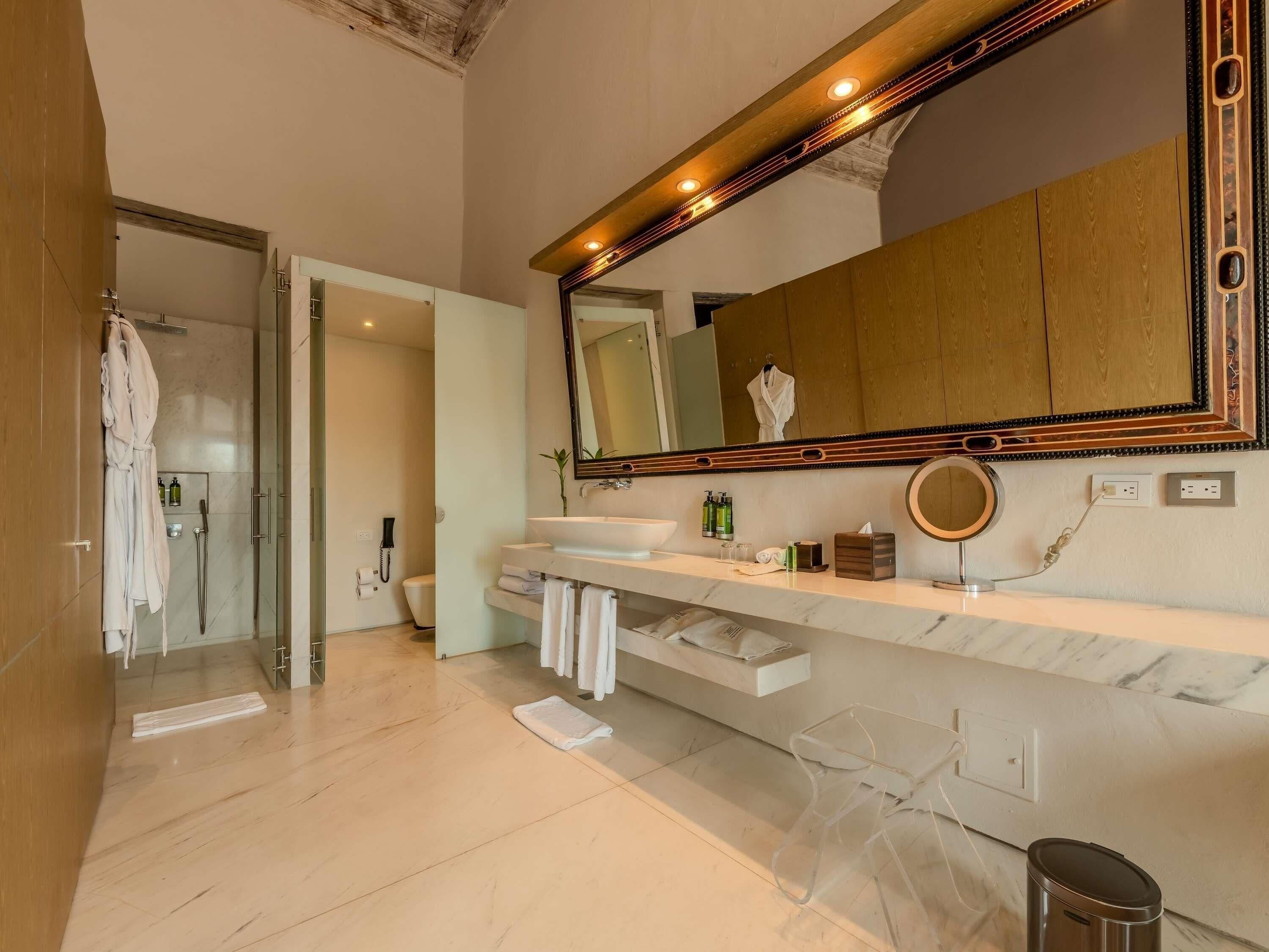 Un bagno moderno con uno specchio grande, un mobile lavabo e una zona doccia.