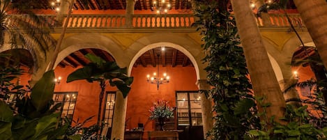 A courtyard with arches, a fountain, and a wooden bench.