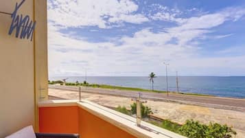 Enjoy the ocean views from this balcony with a wicker sofa and table.