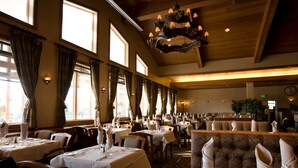 Un restaurant spacieux, doté de nombreuses tables, de hauts plafonds et de grandes fenêtres qui laissent entrer la lumière naturelle.