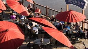 Espace extérieur aménagé avec des parasols rouges au Fairbanks Princess Riverside Lodge.