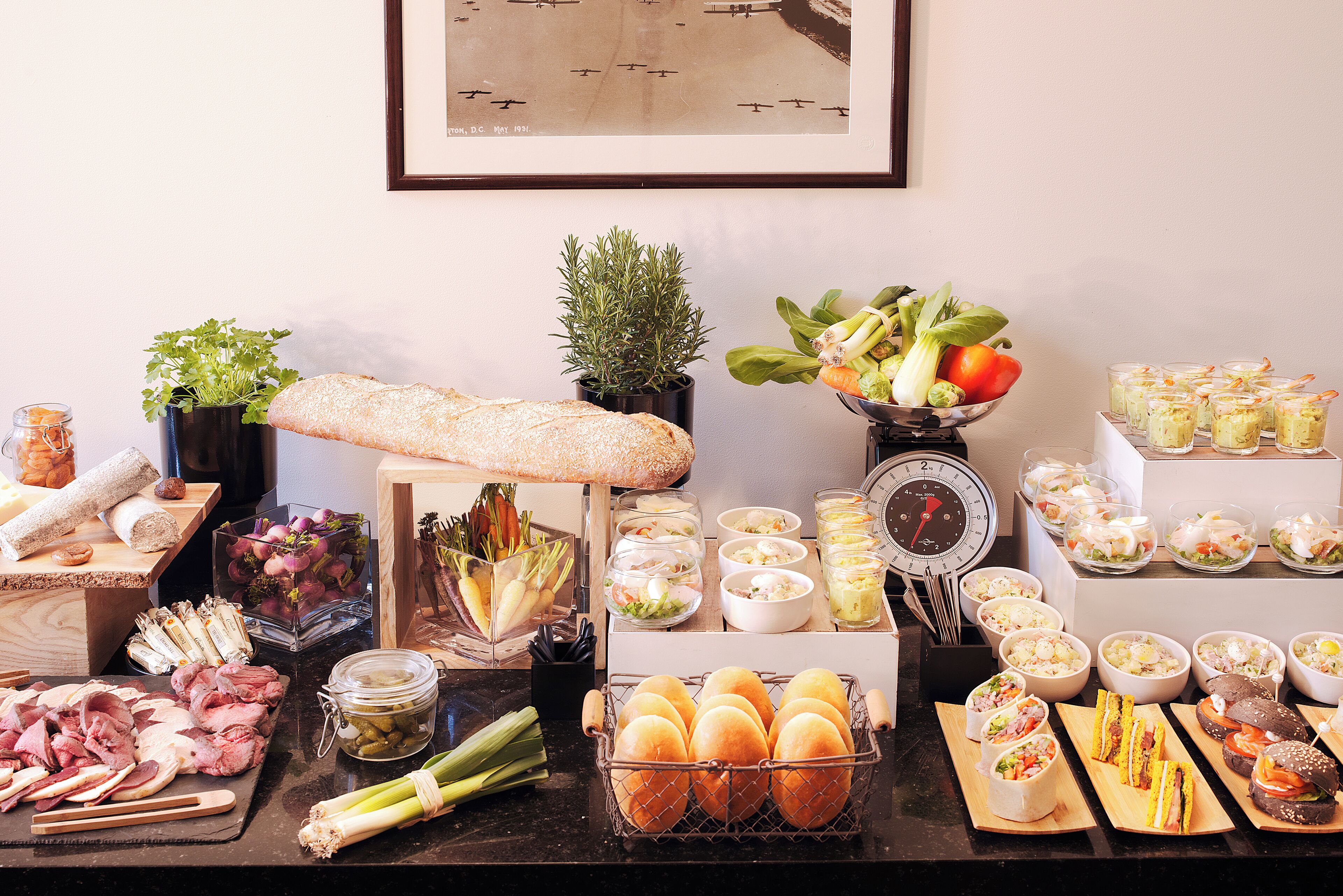 A buffet table with various food items, including bread, salads, and sandwiches.