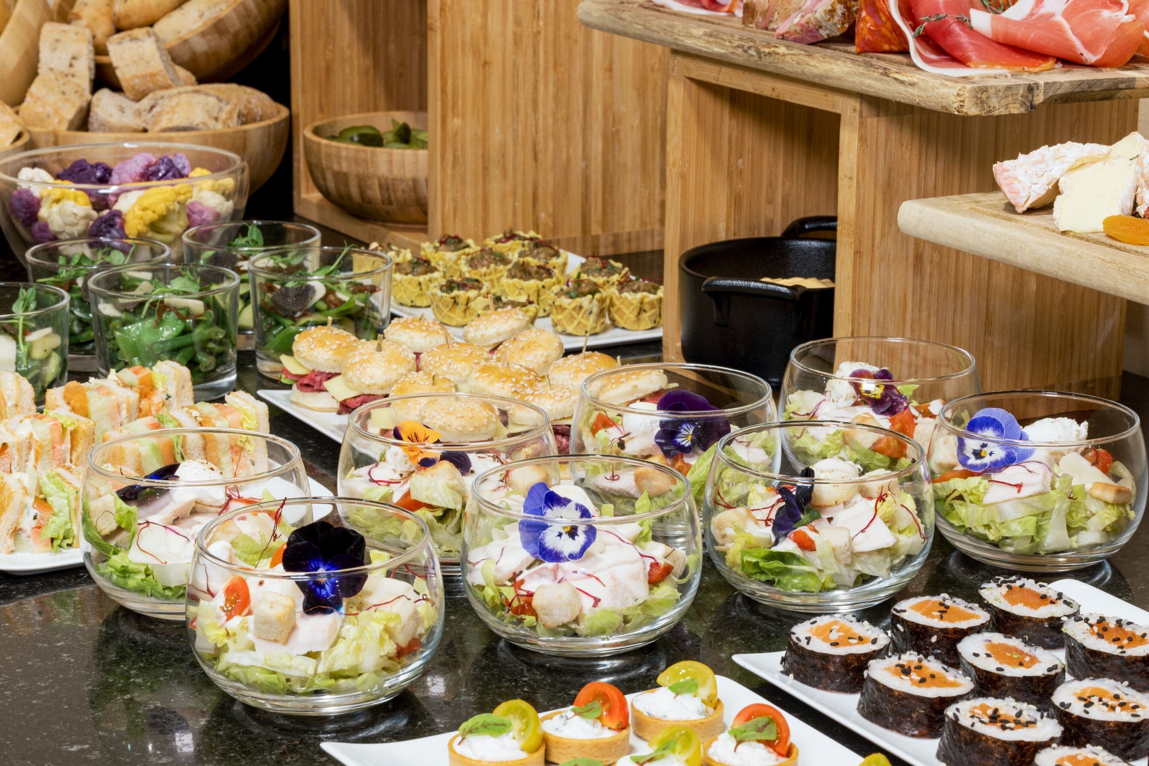 Un buffet proposant une variété de plats, notamment des salades, des sandwichs et des sushis.