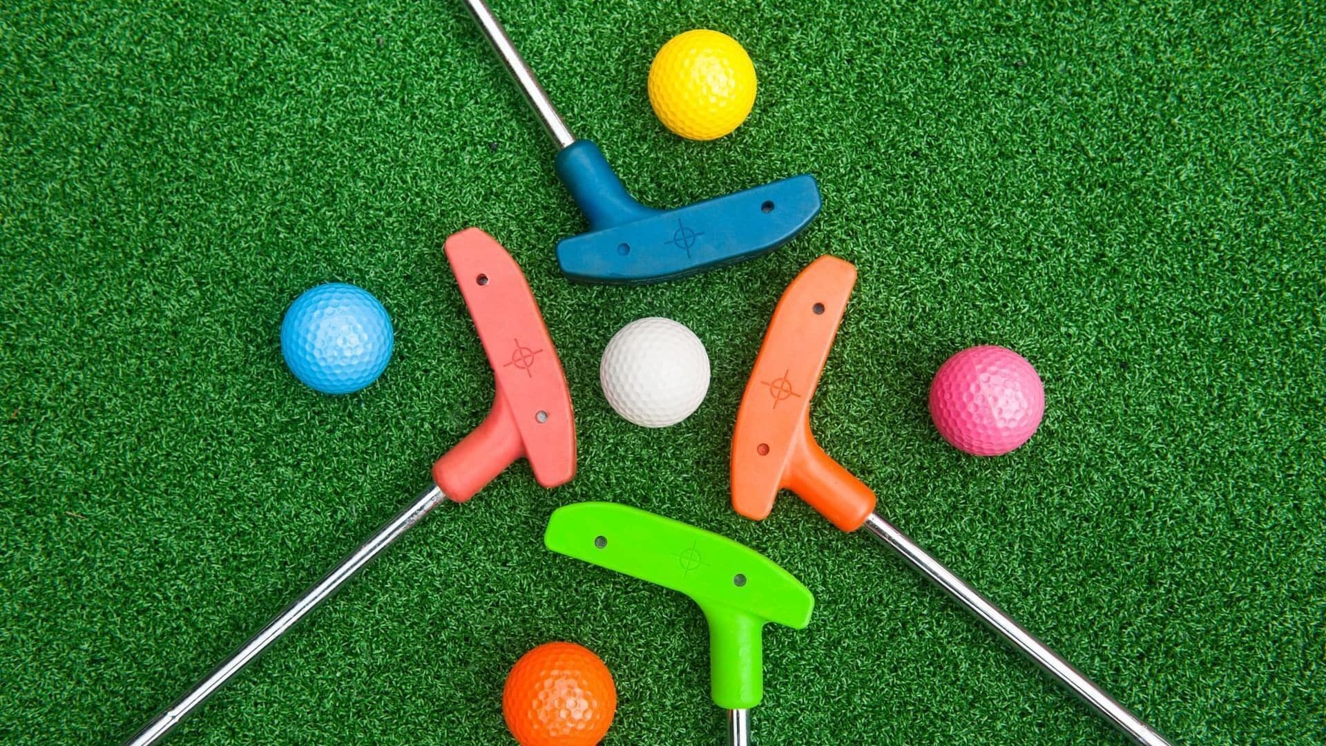 Una serie di mazze da golf e palline su un manto erboso.