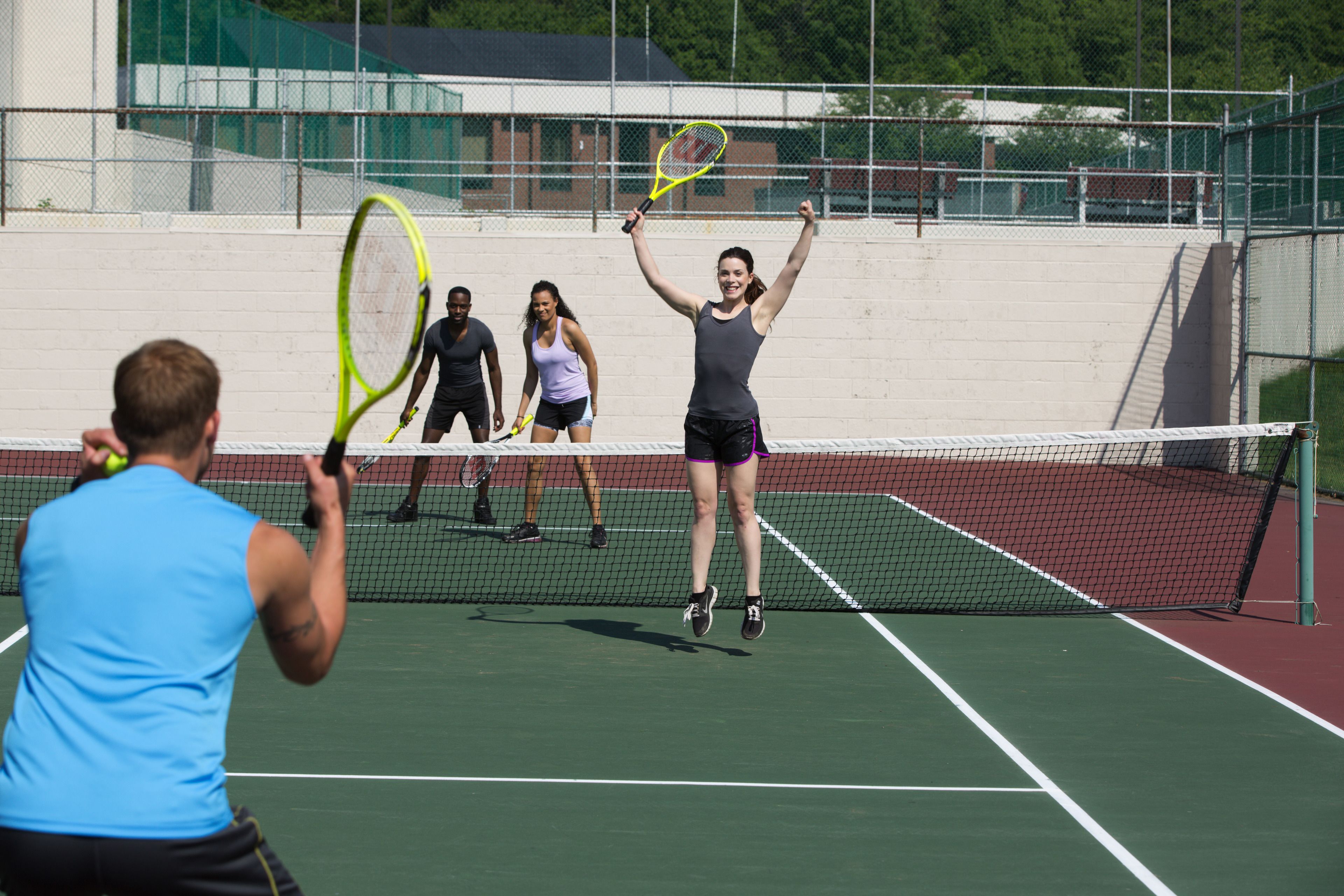 A tennis court with a net, players, and a referee.