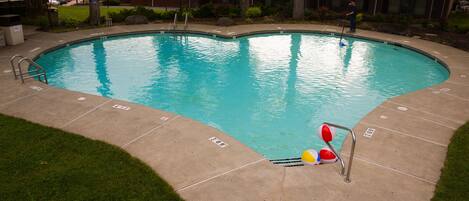 A swimming pool with a lifeguard, a lounge chair, and a sign indicating a 3.00 depth.