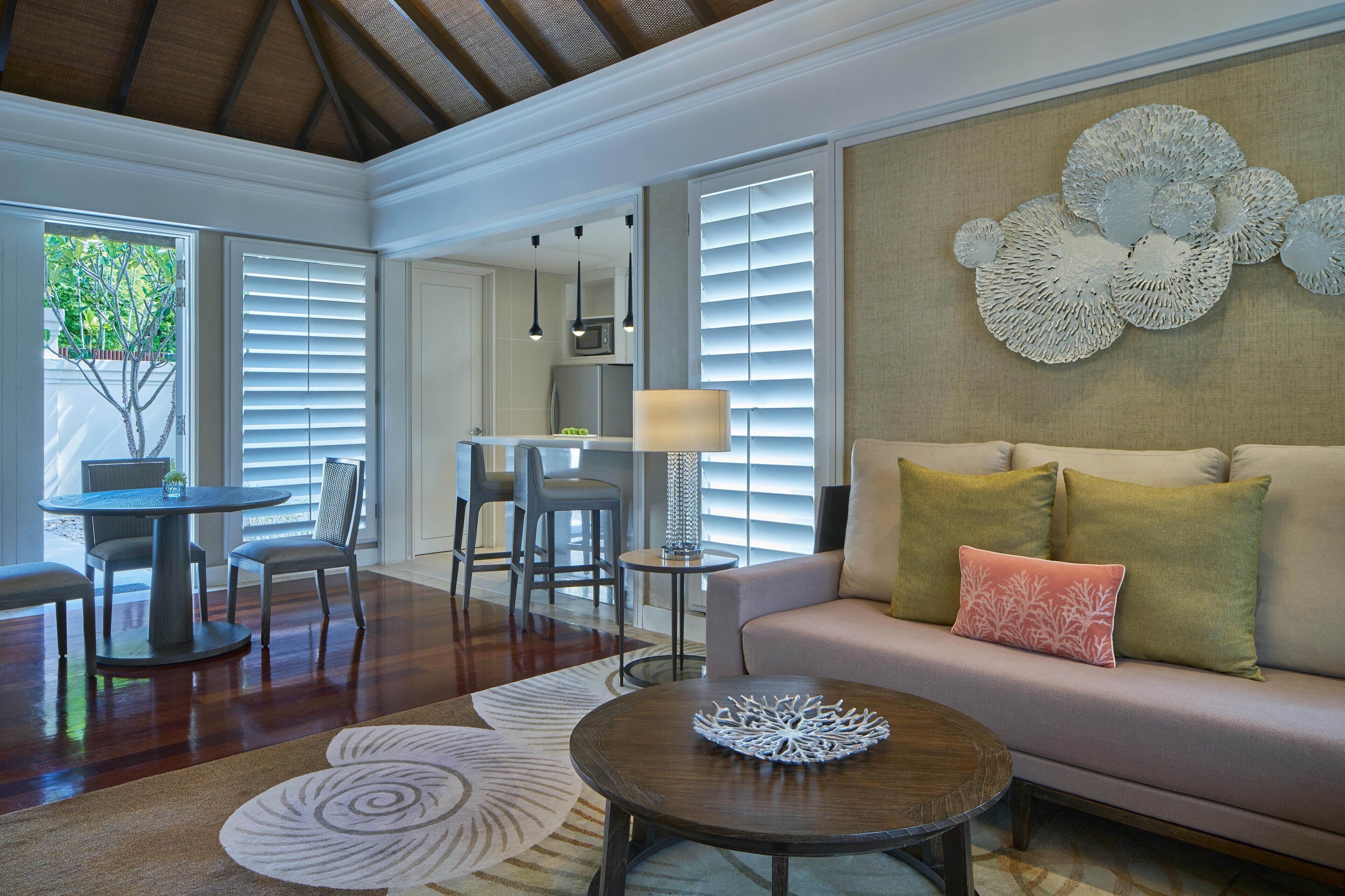 A spacious living area with a sofa, coffee table, and dining set.