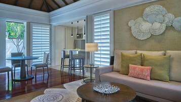 A spacious living area with a sofa, coffee table, and dining set.