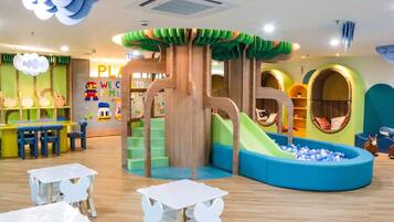 Children can play and socialize in this vibrant play area featuring a slide and ball pit.