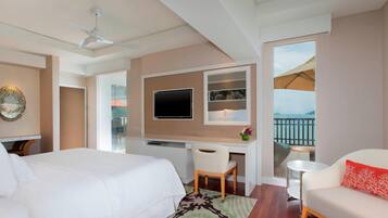 A hotel room with a bed, desk, chair, and a sofa.