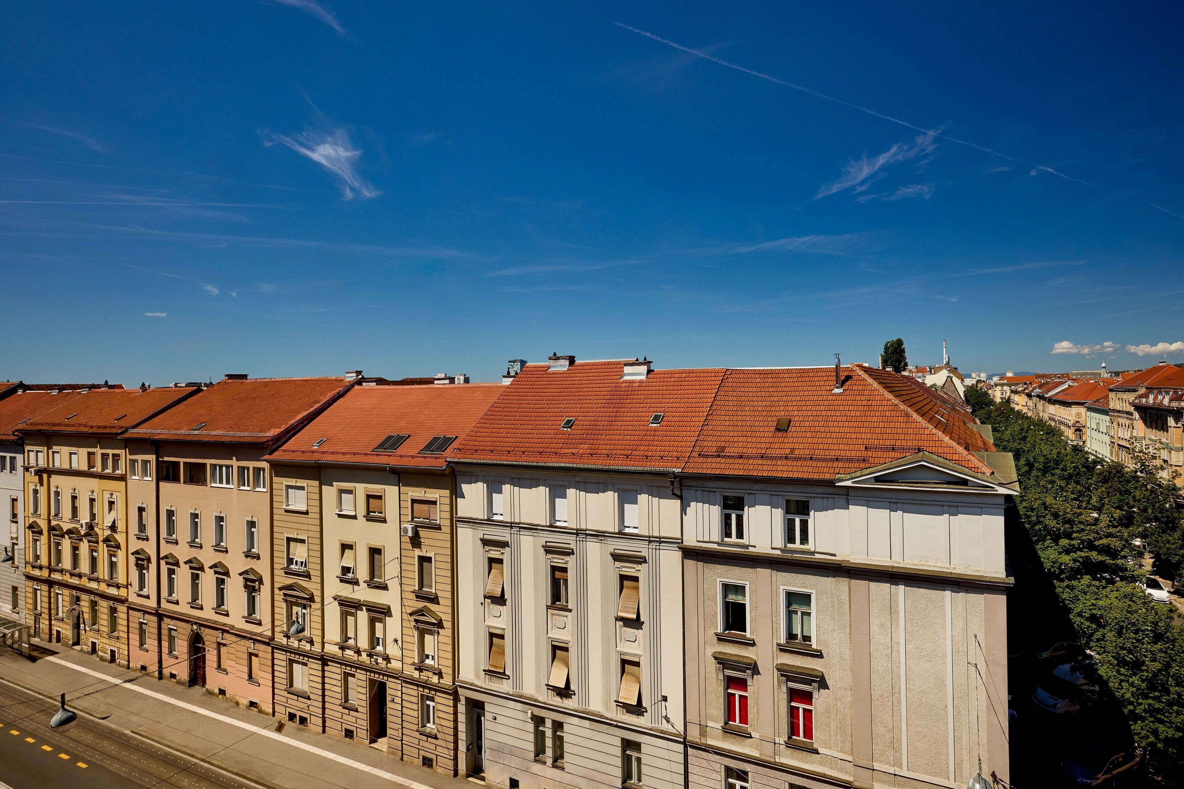 A row of historic buildings with red-tiled roofs and classic architecture.