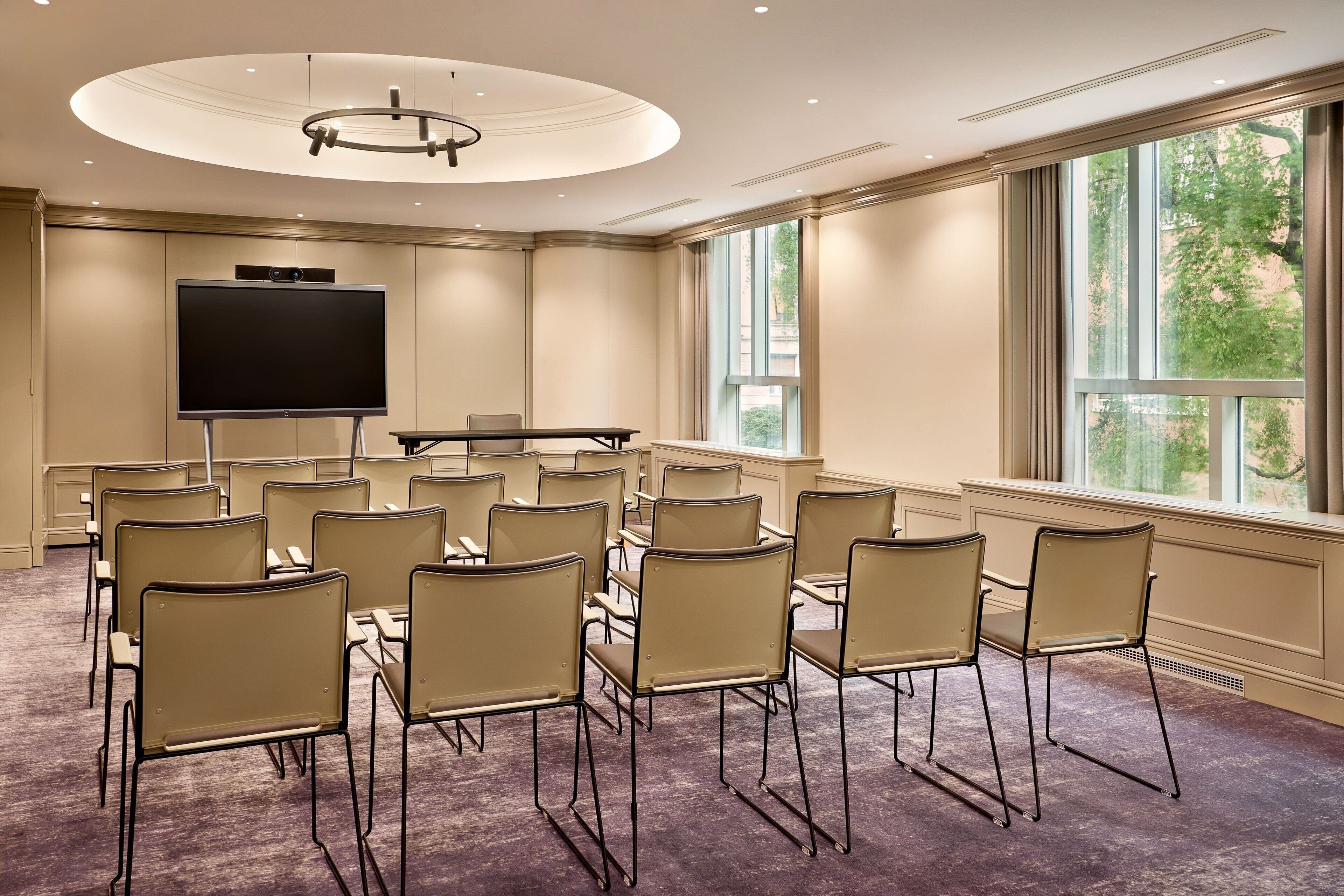 A conference room with a large screen, multiple chairs, and a piano.