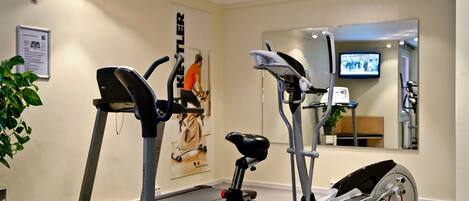 A gym with treadmills, an elliptical, and a stationary bike.
