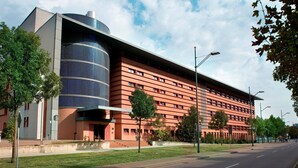 Un bâtiment moderne doté d’une façade en verre incurvé et d’une partie à toit plat.