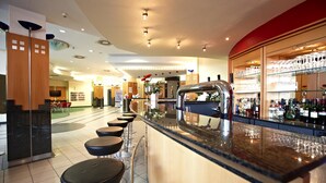 A bar area with a counter, stools, and a glass display case with bottles.