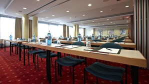 A conference room with long tables, chairs, and water bottles.