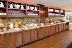 A buffet setup with various food items and serving ware.
