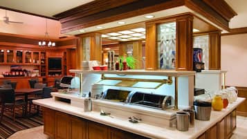 A breakfast bar with a buffet setup, including various food items and beverages.