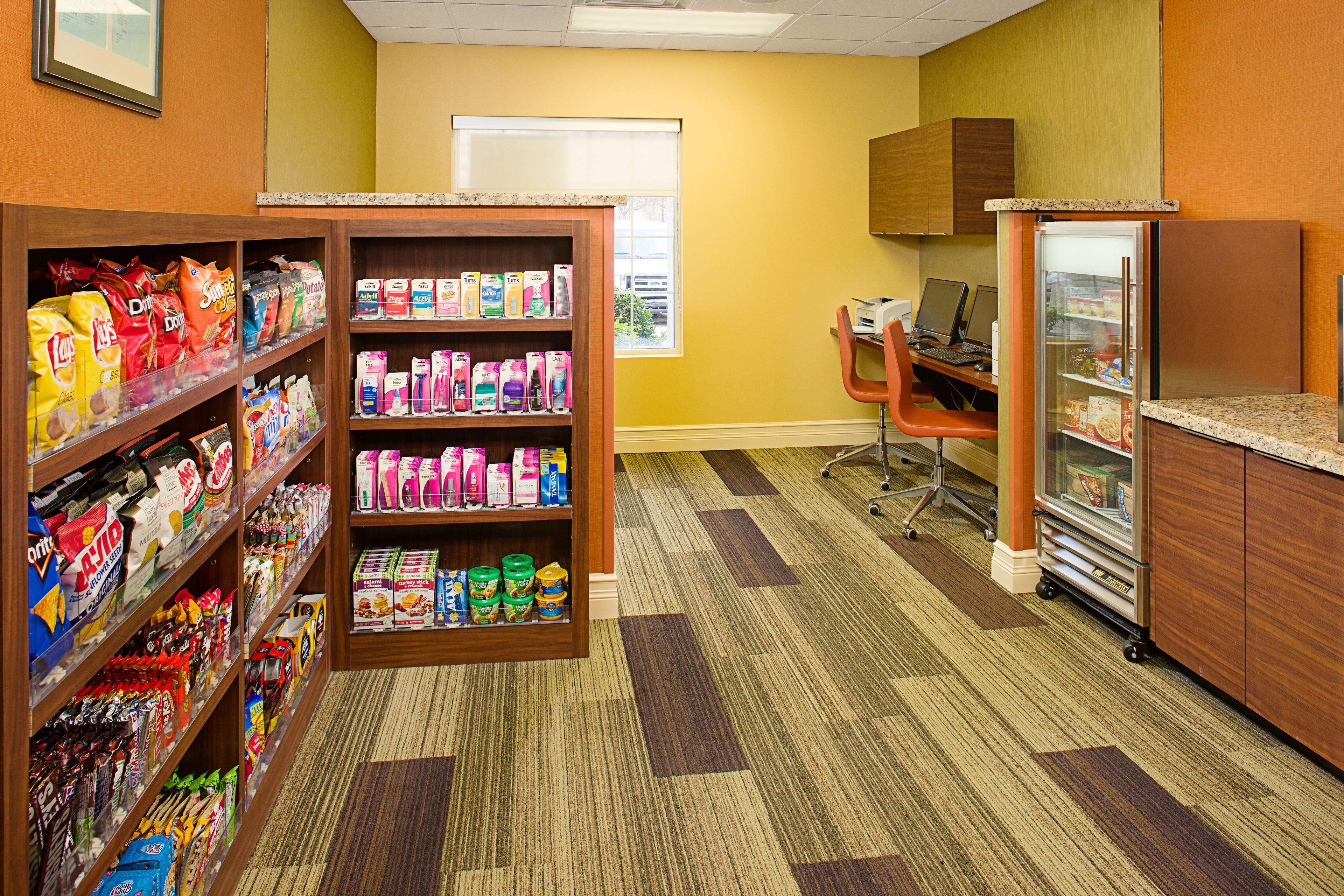 Una tienda de comestibles con estantes llenos de refrigerios, bebidas y otros productos.