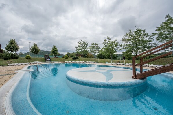 Una piscina cubierta, una piscina al aire libre