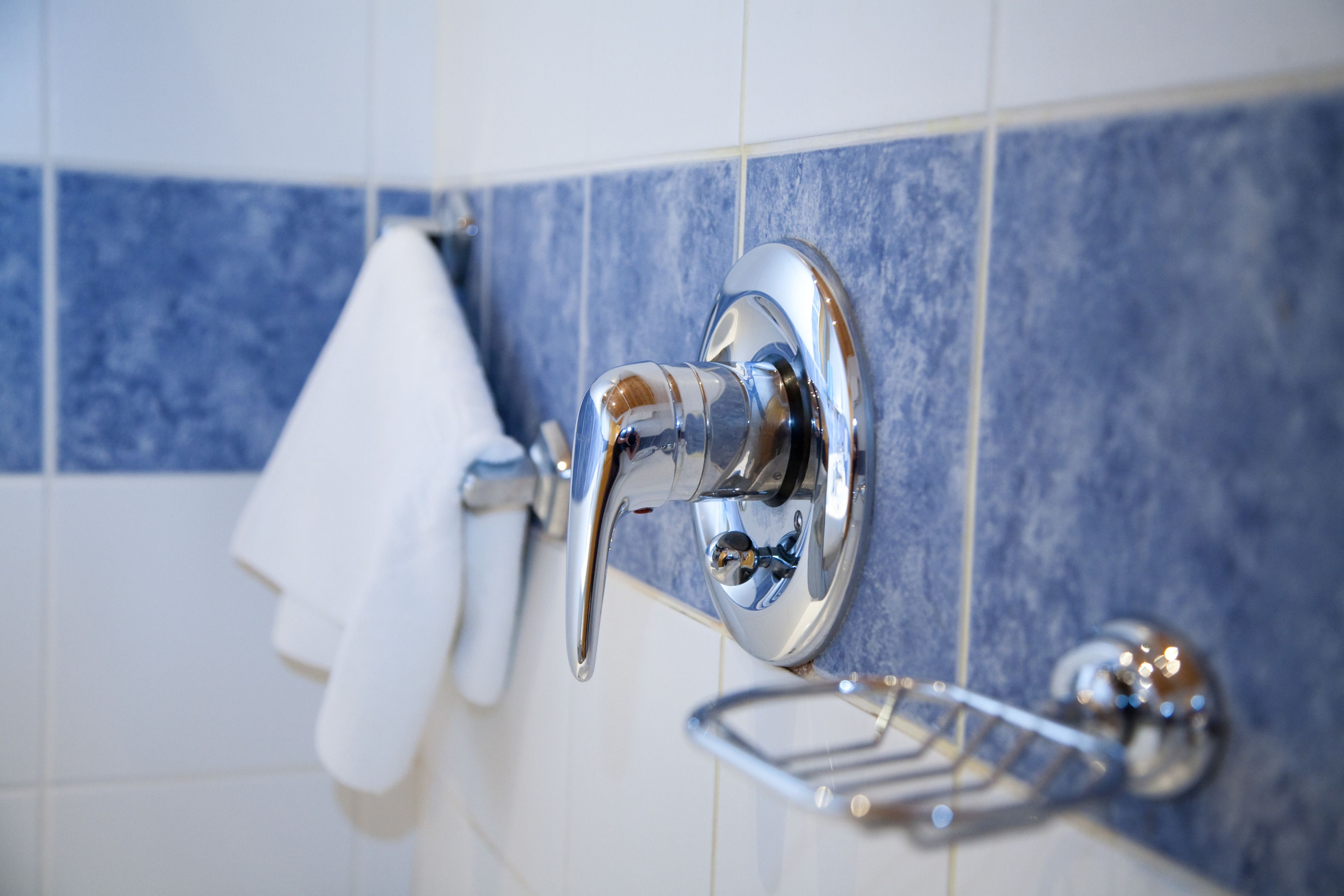 Un baño con grifo de cromo, toallero y jabonera.