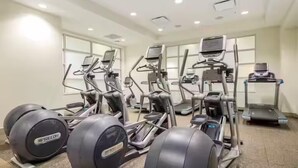 Un gimnasio con múltiples cintas de correr, elípticas y bicicletas estáticas.