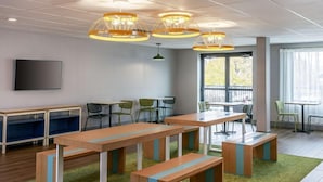 Una sala de reuniones moderna con mesas largas, bancos y sillas.