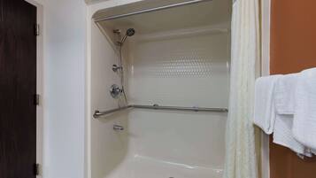 Eine Badewanne mit Duschkopf, einer Haltestange und einem Handtuchhalter.
