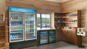 A corner of a room with wooden walls, a window, and a vending machine.