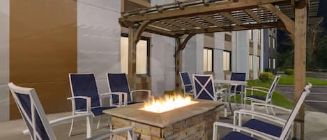An outdoor seating area with a fire pit and chairs.