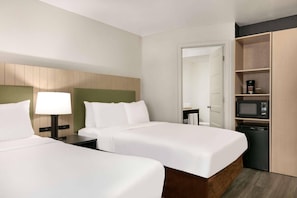 A hotel room with two beds, a bedside table with a lamp, a microwave, and a small refrigerator. - Country Inn & Suites by Radisson, Roanoke Rapids, NC (Roanoke Rapids)