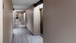 A long, narrow hotel corridor with a light-colored floor and beige walls. - Sleep Inn Fayetteville I-95 (Fayetteville)