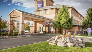 A Sleep Inn hotel with a covered entrance, American flag, and a sign indicating the number of rooms. - Sleep Inn Provo near University (Provo)