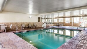 An indoor swimming pool with tiled floors, a clear pool, and several chairs along the walls. - Sleep Inn Provo near University (Provo)