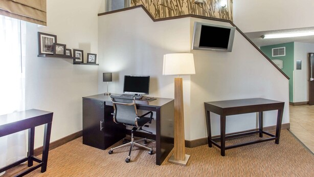 A hotel room with a desk, chair, lamp, TV, and framed pictures on the wall. - Sleep Inn Provo near University (Provo)
